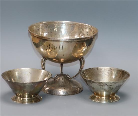 A modern Arts & Crafts style planished silver bowl on stylised supports by Francis Howard Ltd and a pair of smaller silver dishes.